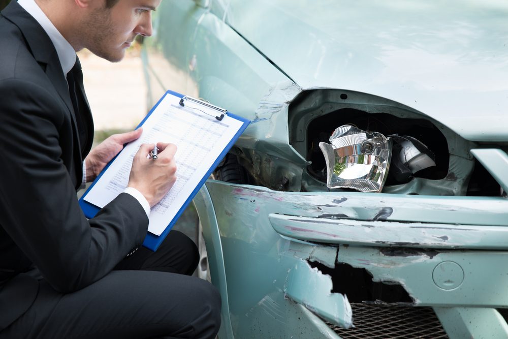 An insurance agent examines and takes notes while viewing a vehicle damaged in a car wreck. How long does an insurance company have to investigate a claim?